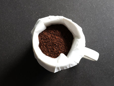 Coffee grounds in coffee with filter  on black granite counterの写真素材