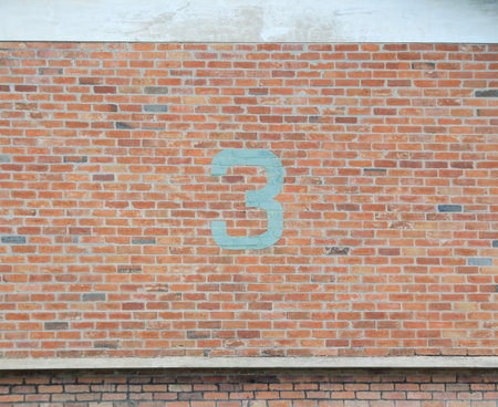 Number 3 painted on old brick wall.