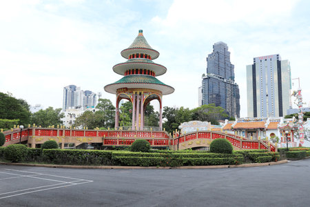 BANGKOK ,THAILAND - NOV 13 : Traditional Chinese style round two-tier roofs pagoda with modern business building in background at Taechew Park on November 13, 2022 in Bangkok, Thailand.のeditorial素材