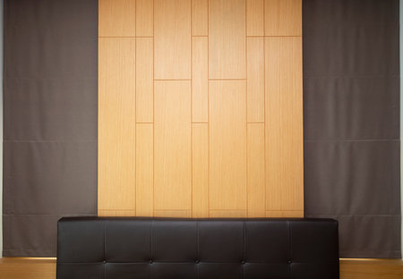 Brown leather headboard decorated with wooden wall and brown curtain.の写真素材