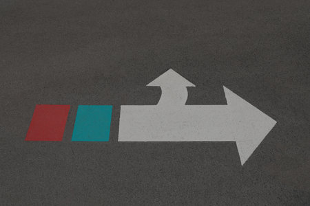White arrow sign with green and red on the end. of the sign.