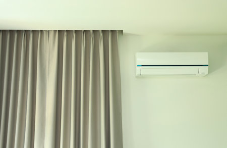Air conditioner wall type with curtain in white wall room.の写真素材