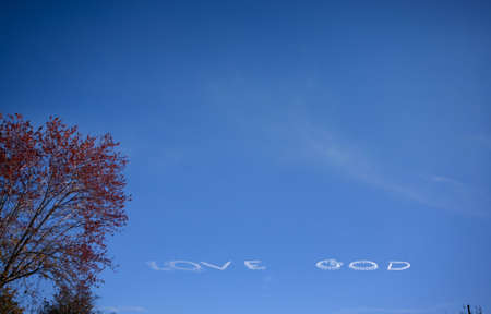 White LOVE GOD text created with airplane  jet at blue sky の写真素材