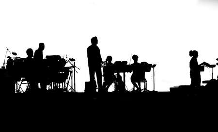 Musicians of rock band playing on tablets in black and white silhouetteの写真素材