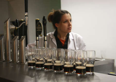 Dublin, Ireland - June 19, 2008: Multiple glasses of beer served for tasting at The Guinness Brewery, founded by Arthur Guinness in 1759, where 2.5 million pints of stout are brewed daily.のeditorial素材