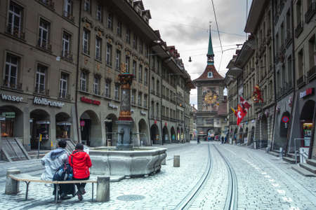 BERN, SWITZERLAND - APRIL 21, 2014: People on the shopping alley Kramgasse with the famous clock tower Zytglogge in Bern on April 21, 2014.のeditorial素材