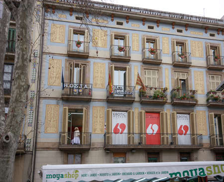 BARCELONA, SPAIN - FEB 9, 2014: Young woman at balcony invites people from Rambla street to visit Erotic Museum in Barcelona Spain on Feb 9, 2014のeditorial素材