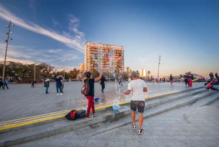 BARCELONA, SPAIN - NOVEMBER 10, 2015: Unidentified man and woman blow large soap bubbles on Placa del Mar in the evening for tourists on November 10, 2015 in Barcelona, Spain.のeditorial素材