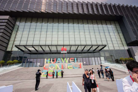 SHANGHAI, CHINA - SEPTEMBER 2, 2016: Attendees of Huawei Connect 2016 information technology conference and exhibition near entrance to Expo Center in Shanghai, China on September 2, 2016.のeditorial素材