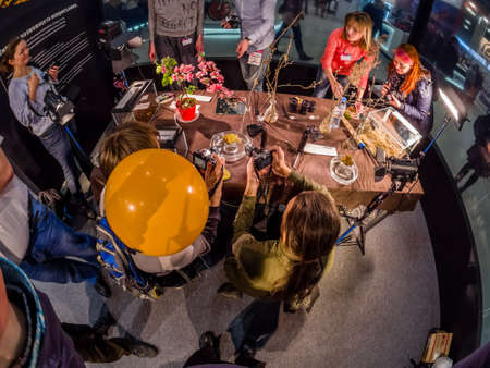 MOSCOW, RUSSIA - APRIL 21, 2017: Visitors take part in macro photography workshop at booth of Olympus company at PhotoForum 2017 trade show and exhibition in Moscow, Russia on April 21, 2017.のeditorial素材