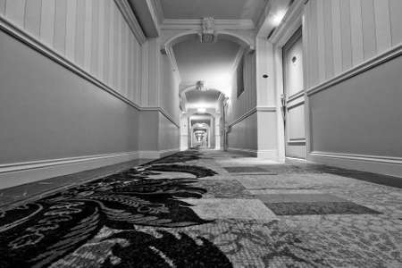 Perspective hotel corridor view with carpet and row of lustres.の写真素材