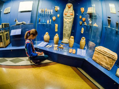 MOSCOW, RUSSIA - JAN 14, 2020: Schoolgirl studies the archaeological finds exposition of the Egyptian hall of Pushkin State Museum of Fine Arts on Jan 14, 2020 in Moscow, Russia.のeditorial素材