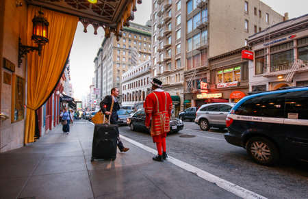 SAN FRANCISCO, USA - OCT 2, 2012: A departing guest of Kimpton Sir Francis Drake hotel asks a doorman in a beefeater suit to call him a taxi on Oct 2, 2012 in San Francisco, USA.のeditorial素材