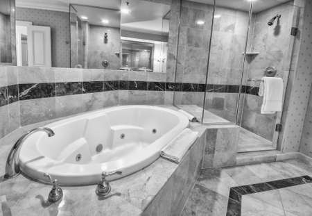 White bathtub bathtub and brass taps decorated with marble tilesの写真素材