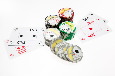 Poker chips and playing cards on white background