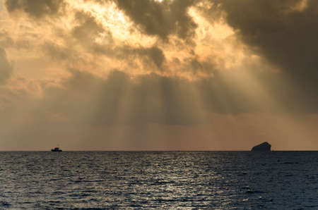 Seascape with the sunbeams going through the clouds