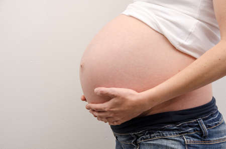 Belly of pregnant woman with handsの写真素材