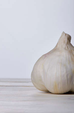 Still life of a head and a clove of garlic with a white background