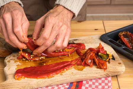 Close up of peeling a roasted pepper. Removing skin and seedsの写真素材