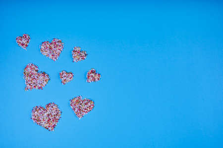 Multicolored confectionery noodle hearts on blue background. St. Valentine's Day. Weddings, Anniversary, Mother's Day. Backgroundの写真素材