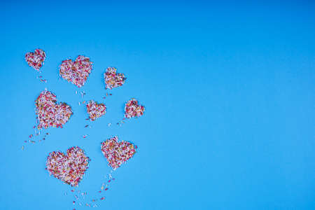 Multicolored confectionery noodle hearts on blue background. St. Valentine's Day. Weddings, Anniversary, Mother's Day. Backgroundの写真素材