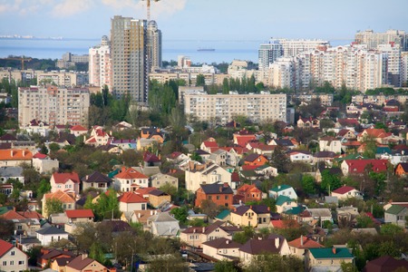 Photo cityscape with blue sky little house with beautiful colored roofs and large tall buildings....