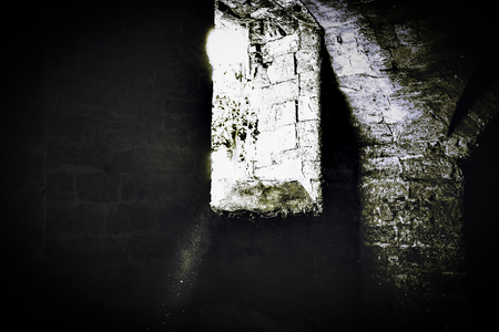 Window of the basement of an abandoned castle with blackout in the style of an old photo of a film.の写真素材