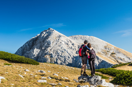 Couple admiring a gorgeous Alpine summit on a sunny autumn dayの写真素材