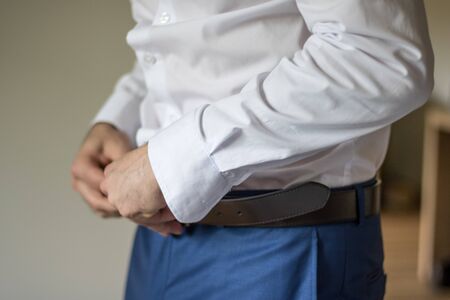 Wedding Groom morning preparations, dress up with white shirt, buttoning upの写真素材