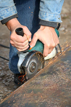 A worker cuts a metal by grinding wheel の写真素材