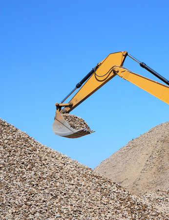 Rubble spilling out of the bucket dredge on background of blue sky