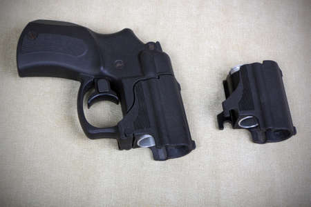 Tubeless doubly charged traumatic pistol and holder with two bullets. Image with vignetteの写真素材