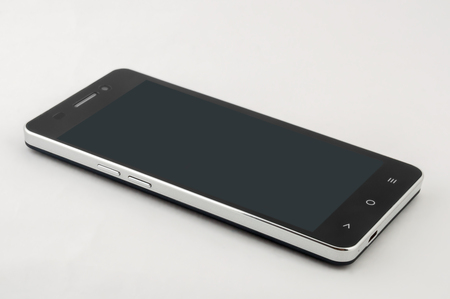 Black smartphone with screen off on white backgroundの写真素材