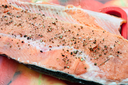 Raw fresh fillet of red fish sprinkled with coarse black pepper