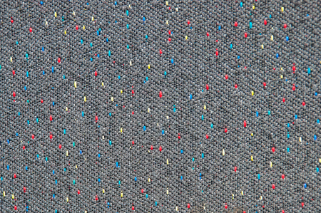 Texture of coarse gray fabric with interspersed red, blue and yellow threadsの写真素材