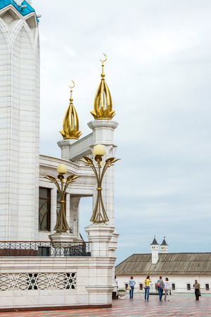 Tatarstan, Kazan - JUNE 20, 2009: Parts of a large white mosque with minarets, domes and a golden crescent and people on the square in the city a cloudy dayのeditorial素材