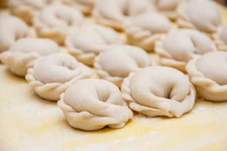 Untreated only molded dumplings lie in rows on a yellow silicone board diagonallyの写真素材