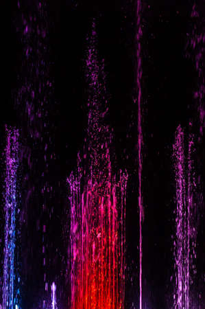 Line of multicolored spitting and dancing fountains with sharp splashesの写真素材