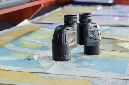 Binocular on the table with nautic mapsの写真素材