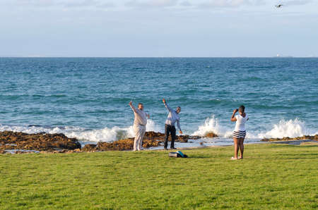 Port Elizabet, South Africa - September 12: Young lady take a picture of the two happy man on September 12, 2015 in Port Elizabet, South Africa.のeditorial素材