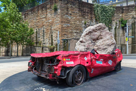 Sydney, Australia - January 9: Big and heavy stone crush a red car on January 9, 2019 in Sydney, Australia.のeditorial素材