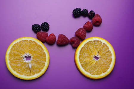 Bicycle from the berries on the purple background