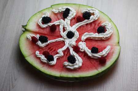 Tasty watermelon pizza with fresh rasberries, blackberries and creamの写真素材