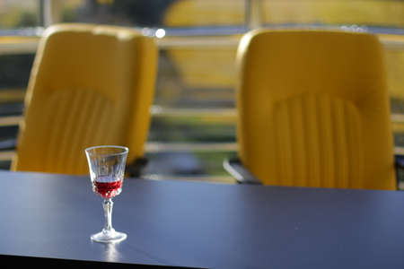 Glass with red wine on the black top in officeの写真素材