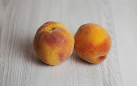 Two freash peaches on the light wooden backgroundの写真素材