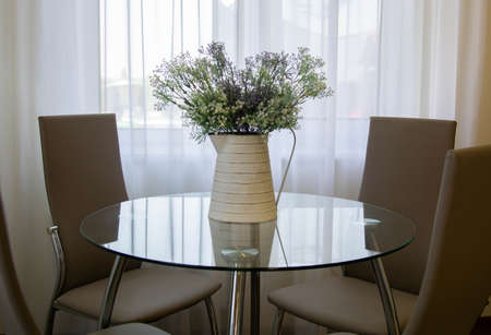 vase standing on glass table in the kitchen Modern white u-shaped kitchen in scandinavian style. Good morningの写真素材