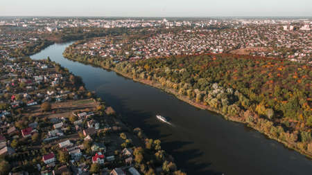 drone with a camera, beautiful river through houses and forestの写真素材