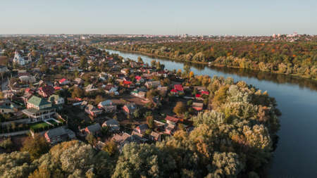 drone with a camera, beautiful river through houses and forestの写真素材
