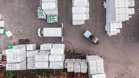forklift driver unloading cargo shipment into a truck trailer. Outdoor. Building materials
