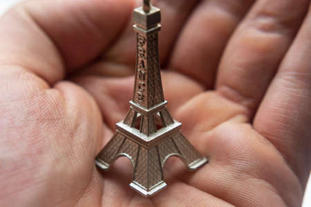 Macro Photography to mini Eiffel Tower in a hand palm. Ideal for travel, adventures and all relatedated with French countryの写真素材
